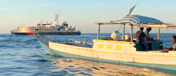 Small boat on water with 5 people on board