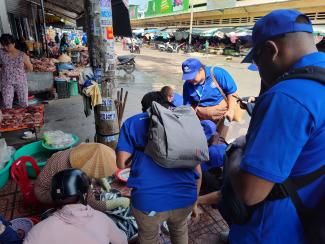 fisheries officers looking at fish being sold in a market in Vietnam