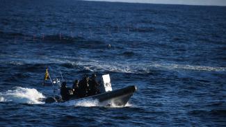 A group of officers on a rigid hull inflatable boat on the high seas.