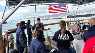 An AFMA fisheries officer taking part in a briefing on a US Coast Guard boat